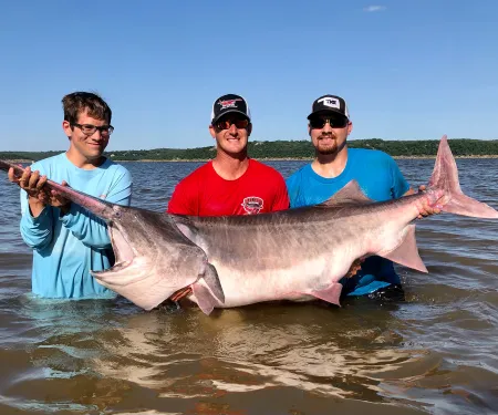 Grant Rader (left) helps hold the state record paddlefish.
