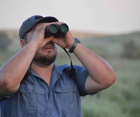 Wildlife viewer looking through binoculars.