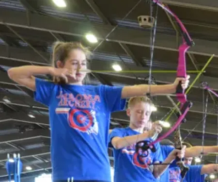 Children archers lining up their bow and arrow to shoot their targets. 