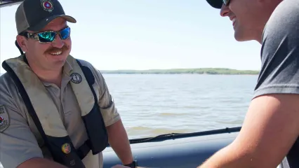 Game warden checking license on boat.