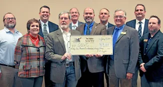 NWTF Oklahoma Chapter members gather around with ODWD Staff while holding giant donation check.