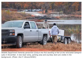 Wildlife Departments fisheries personnel conduct the first stocking of fish at the renovated Dahlgren Lake in November. A new boat ramp, parking area, and courtesy dock are visible in the background. (DON P. BROWN/ODWC)