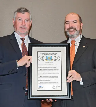 Department Director J.D. Strong presents Teague a framed resolution of appreciation