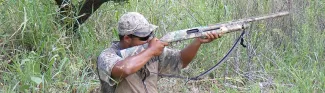 Dove hunter in field with shotgun.