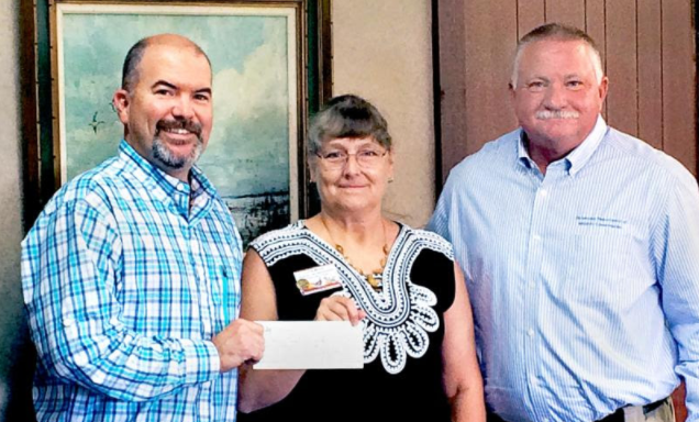 Laura McIver, Oklahoma and Texas regional representative for Quail Forever, presents a check representing donations from three QF chapters to Wildlife Department Director J.D. Strong (left), and Wildlife Division Chief Alan Peoples for equipment and upland game conservation activities at two WMAs.  [DON P. BROWN / ODWC]