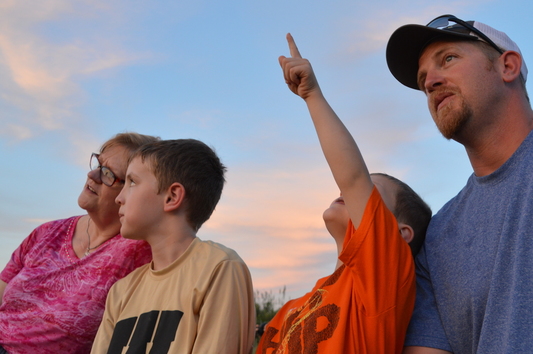A family watches bats emerge from the Selman Bat Cave. Children must be 8 or older to attend. (Blake Podhajsky/ODWC)