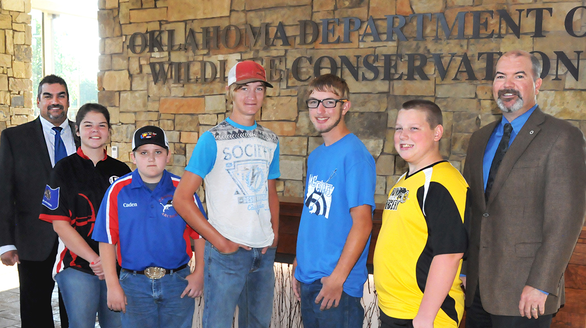 Oklahoma Archery in the Schools students who placed among the top five in NASP national shoots stand with OKNASP coordinator Jay Rouk, left, and Wildlife Department Director J.D. Strong, right. The archers are, from left, Madison Spoonemore, Locust Grove; Cayden Eyestone, Chandler; Jarod Aycox, Zaneis; Karson Warrington, Healdton; and Reece Marble, Salina. (Don P. Brown/ODWC)