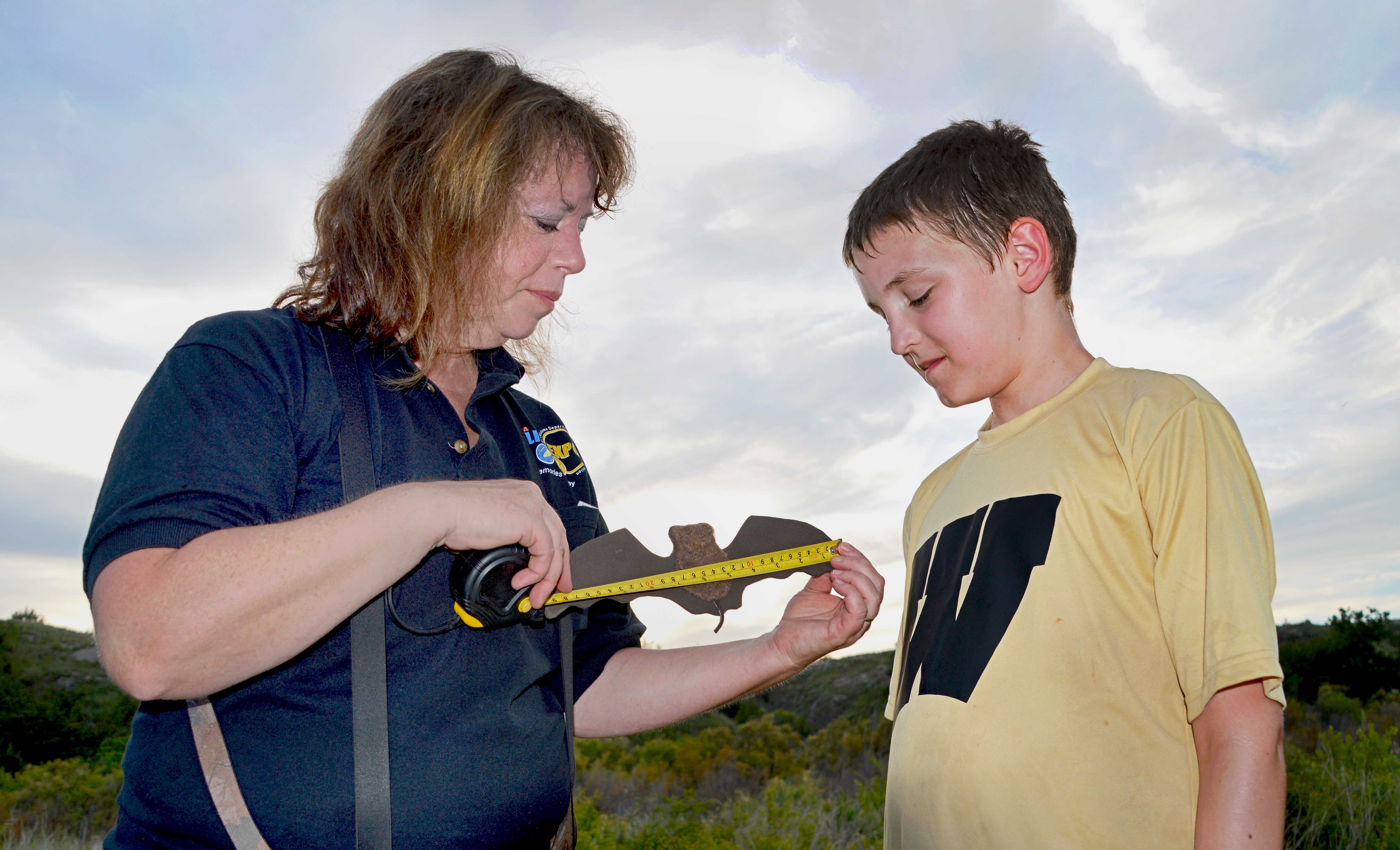 Wildlife biologist Melynda Hickman uses a model of a bat to educate a youngster during a Selman Bat Watch program. Hickman was named 2018 Wildlife Biologist of the Year by the Southeastern Association of Fish and Wildlife Agencies. (Blake Podhajsky/ODWC)