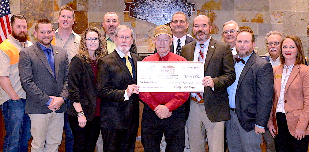 Gathered for presentation of a $124,479 donation from the Oklahoma chapter of National Wild Turkey Federation are, from left, Garrett McClendon, Jared McJunkin, Jeff Springman, NWTF State President Kamara Gatz, Jared Cullison, O.D. Curry, Earl Gilbert, Assistant Chief of Wildlife Bill Dinkines, ODWC Director J.D. Strong, Don Chitwood, T.J. Goodpasture, Rick Nolan and Leah Lowe. (Don P. Brown/ODWC)