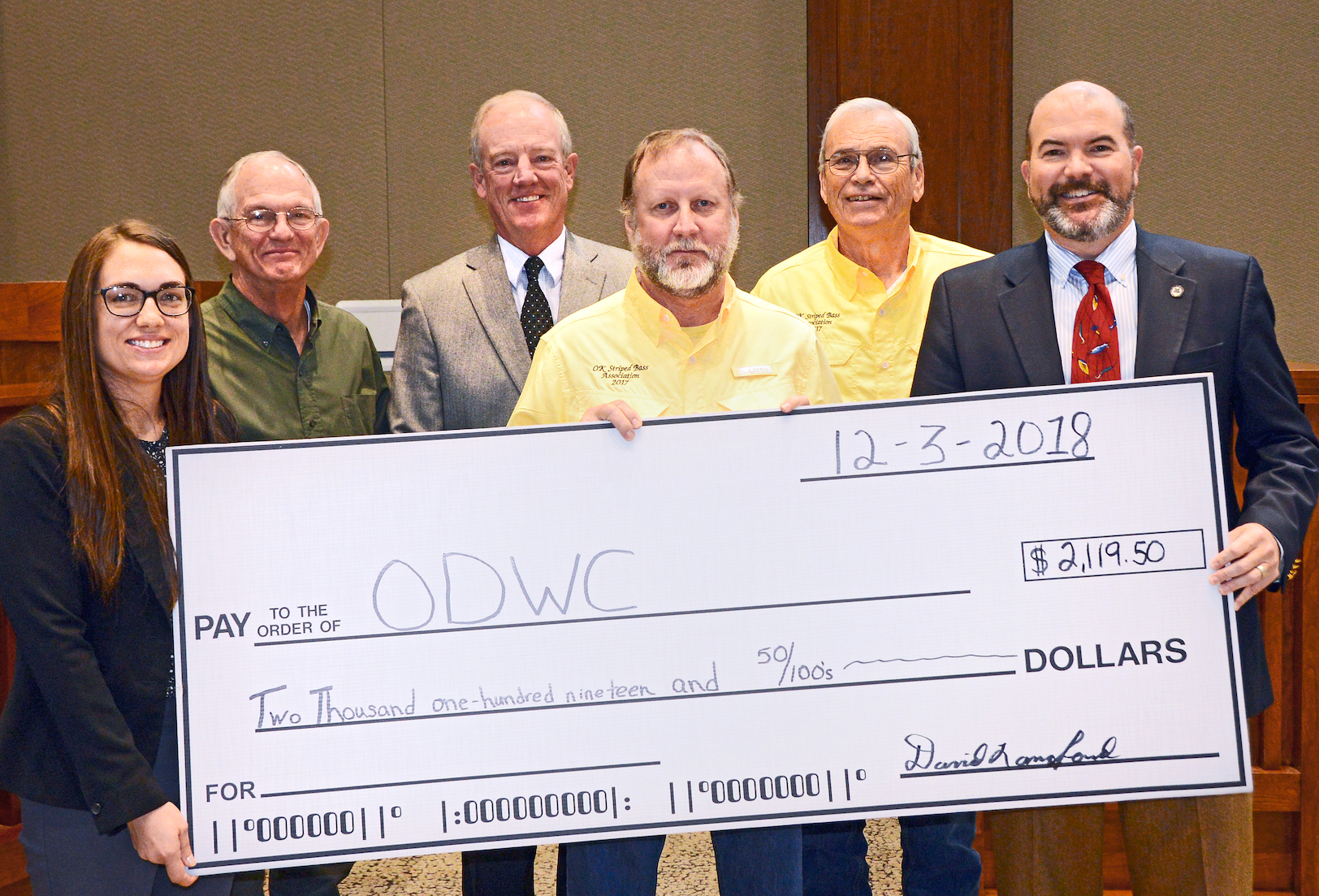 Gathered for a donation from the Oklahoma Striped Bass Association are, from left, Wildlife Department Fisheries Biologist Ashley Nealis, Ed Wampler of OSBA, Department Fisheries Chief Barry Bolton, David Langford of OSBA, Jerry Sikes of OSBA, and Department Director J.D. Strong. (Don P. Brown/ODWC)