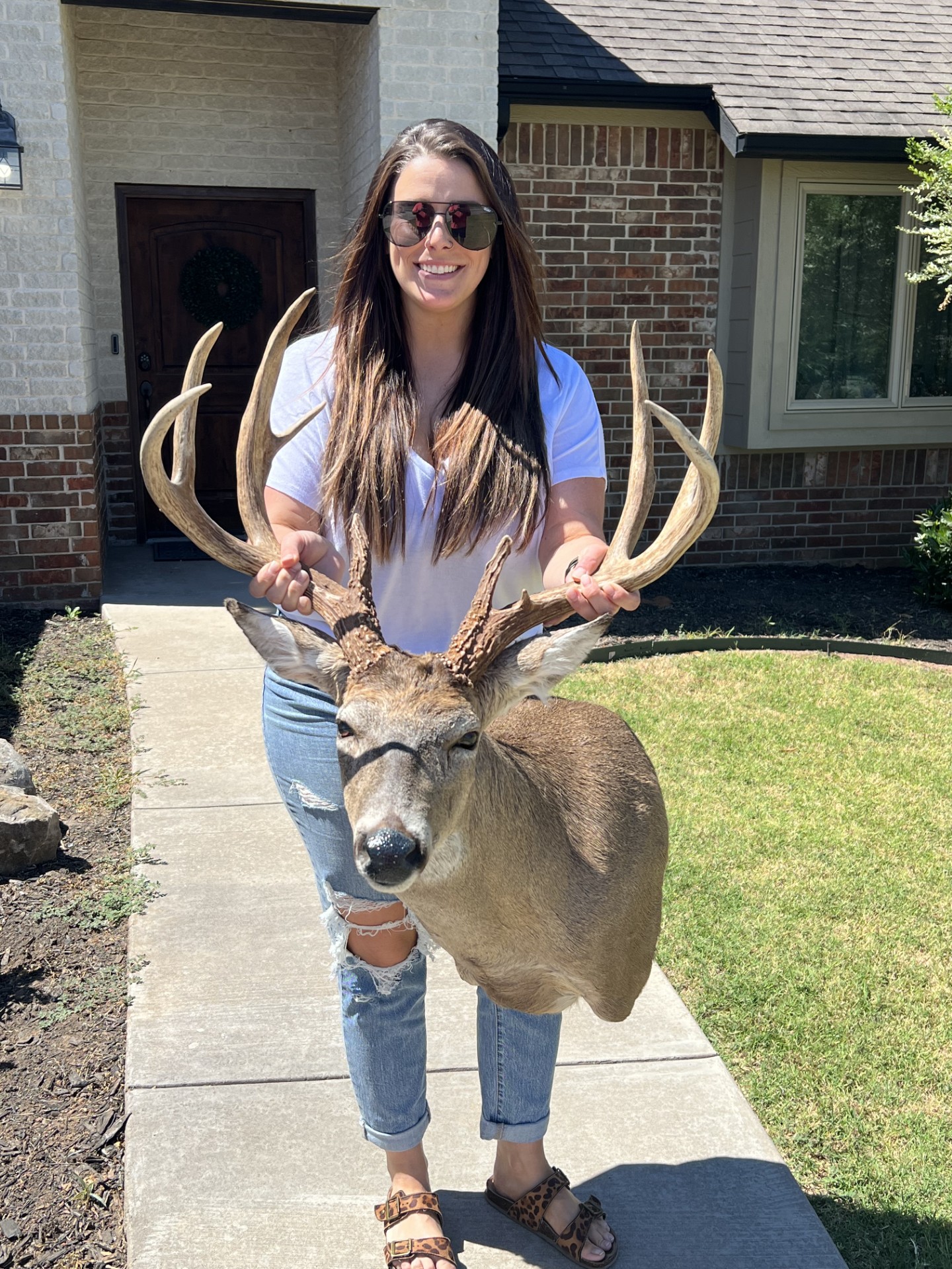 girl holding mounted deer rack 