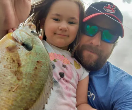 Daughter with father holding fish.