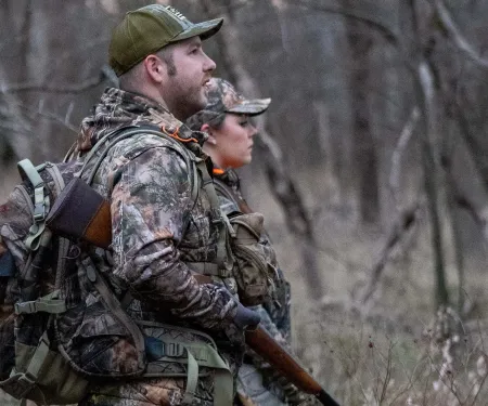 Man and woman in the field hunting squirrel.  Photo by Smokey Solis.