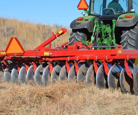 Tractor disc on field.