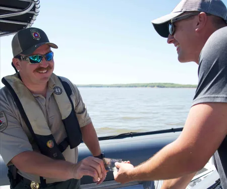 Game warden checking license on boat.