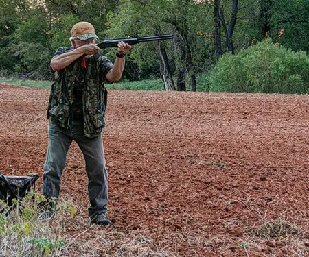 Man in field dove hunting.