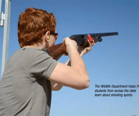 Kid shooting shotgun.