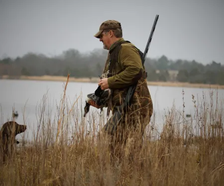 A male hunter and his dog are enjoying opening day of Oklahoma's waterfowl season.