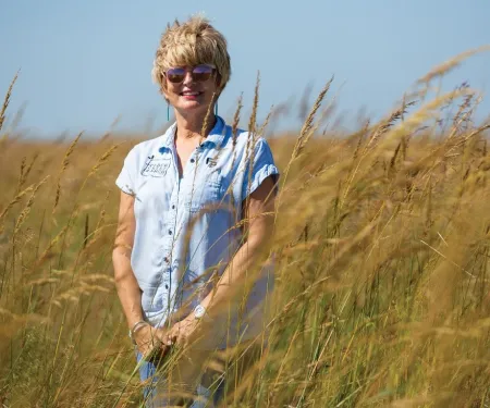 Susan Bergen stands in a field. 