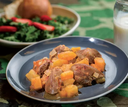 A plate of baked dove breasts smothered in apples and vegetables