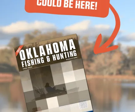 A promotional graphic showing a blurred outdoor lake scene in the background. At the top, an orange speech-bubble banner with an arrow reads “YOUR PHOTO COULD BE HERE!” Below it, an angled mock-up of the Oklahoma Fishing & Hunting Regulations 2025–2026 booklet is displayed, featuring a placeholder grid image of a person fishing from a kayak.