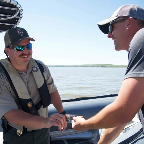 Game warden checking license on boat.