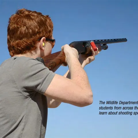 Kid shooting shotgun.