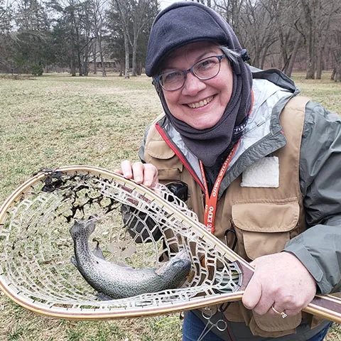 Woman with trout in dip net.