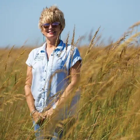 Susan Bergen stands in a field. 