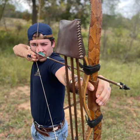 A man draws a bow with an arrow