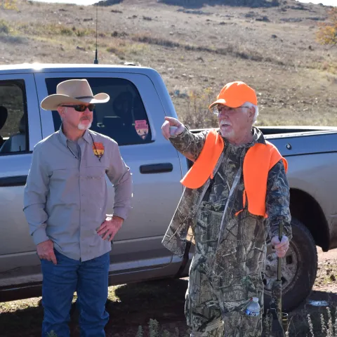 A biologist and a hunter have a conversation in the field. 