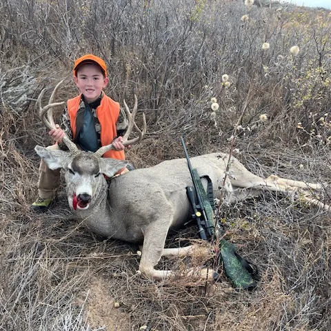 boy with mule deer buck