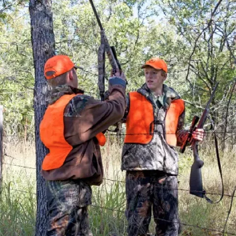 2 young hunters wearing orange vests.