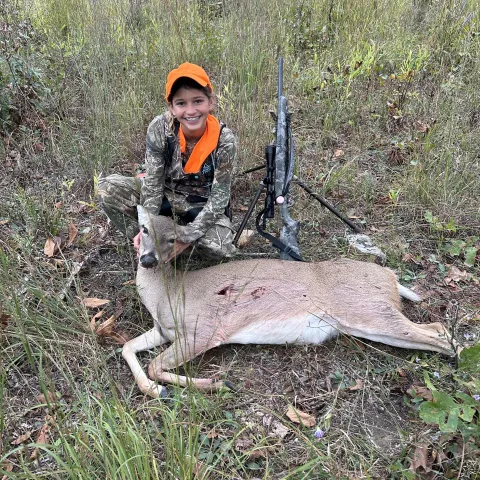 Young hunter pictured with harvested deer.