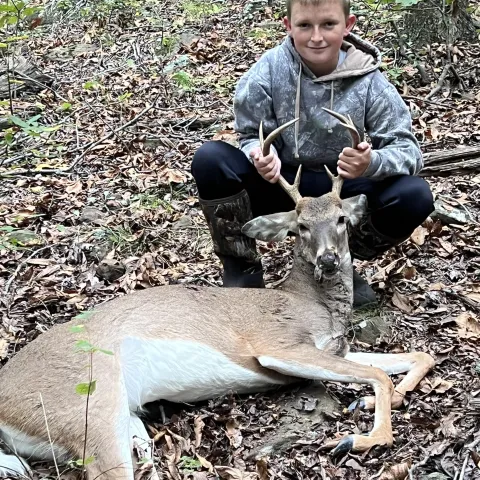 Young hunter pictured with harvested deer.