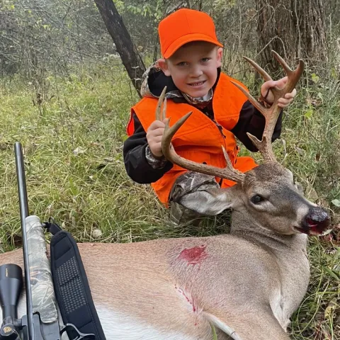Young hunter pictured with harvested deer.