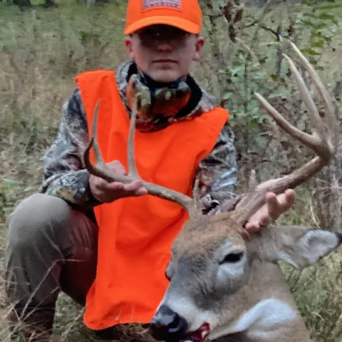 Young boy pictured with harvested deer.