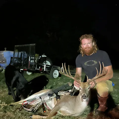 Hunter pictured with harvested deer he caught during archery season.
