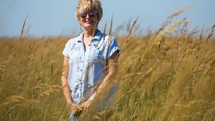 Susan Bergen stands in a field. 