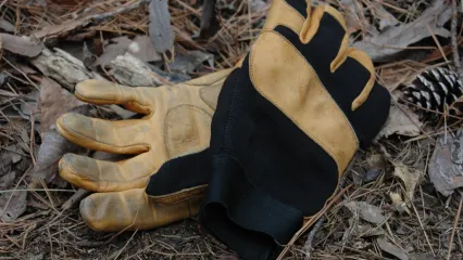 a pair of leather and black fabric gloves