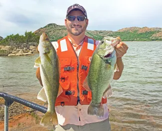 Healthy walleye and largemouth bass are showing up in recent fish sampling efforts at Altus-Lugert Lake in the Quartz Mountains, as shown here by Ryan Ryswyk, Southwestern Region Fisheries supervisor for the Oklahoma Department of Wildlife Conservation.