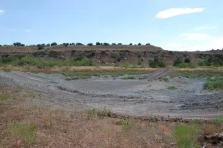 Pond Construction - Pond bed with gravel and no water.