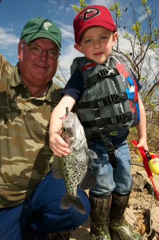 Man and boy with crappie.