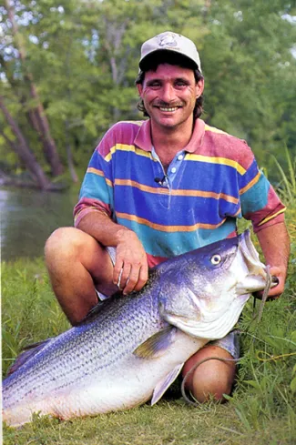 Louis Parker holding state record striped bass.