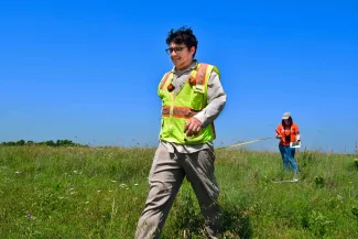David Berman and Emily Geest stretch a measuring tape to gauge the density of milkweeds and other blooming plants in their study area.
