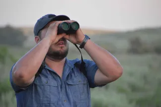 Wildlife viewer looking through binoculars.