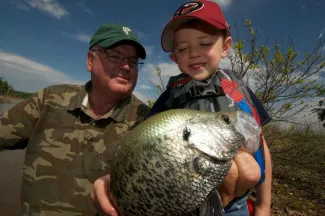 Man and boy admire caught crappie.