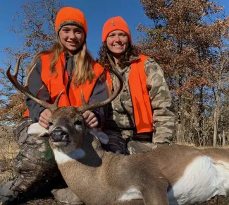 Woman and girl in the field with buck, photo by Dru Polk.