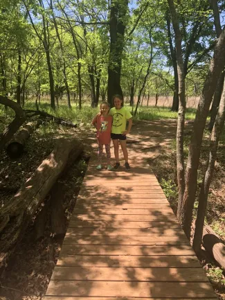 Two girls on a bridge outdoors exploring.