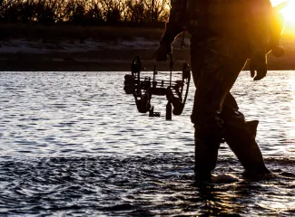 Hunter with bow in water, photo by Nick Spears/RPS